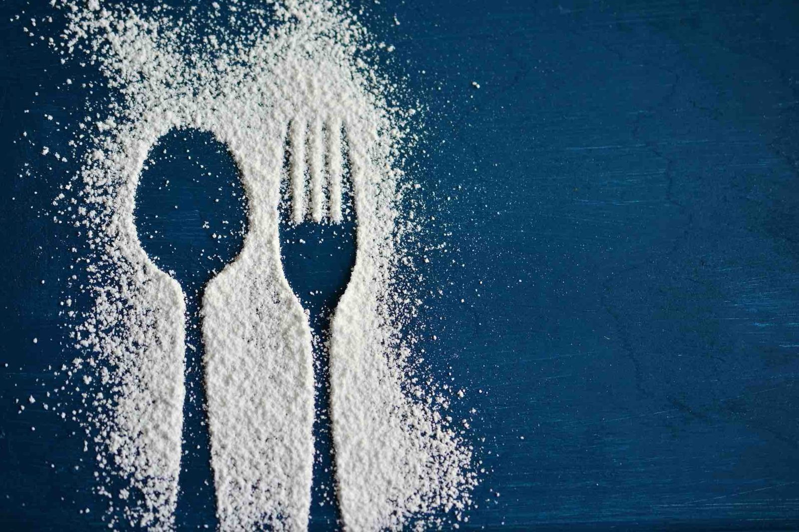 white processed powder outlining spoon and fork