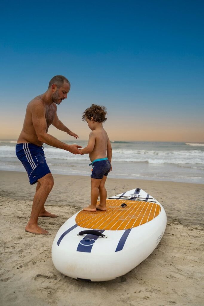 Dad with no belly fat and natural weight loss teaches son paddleboard