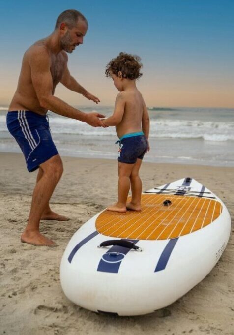 Dad without belly fat and natural weight loss teaches son paddleboard