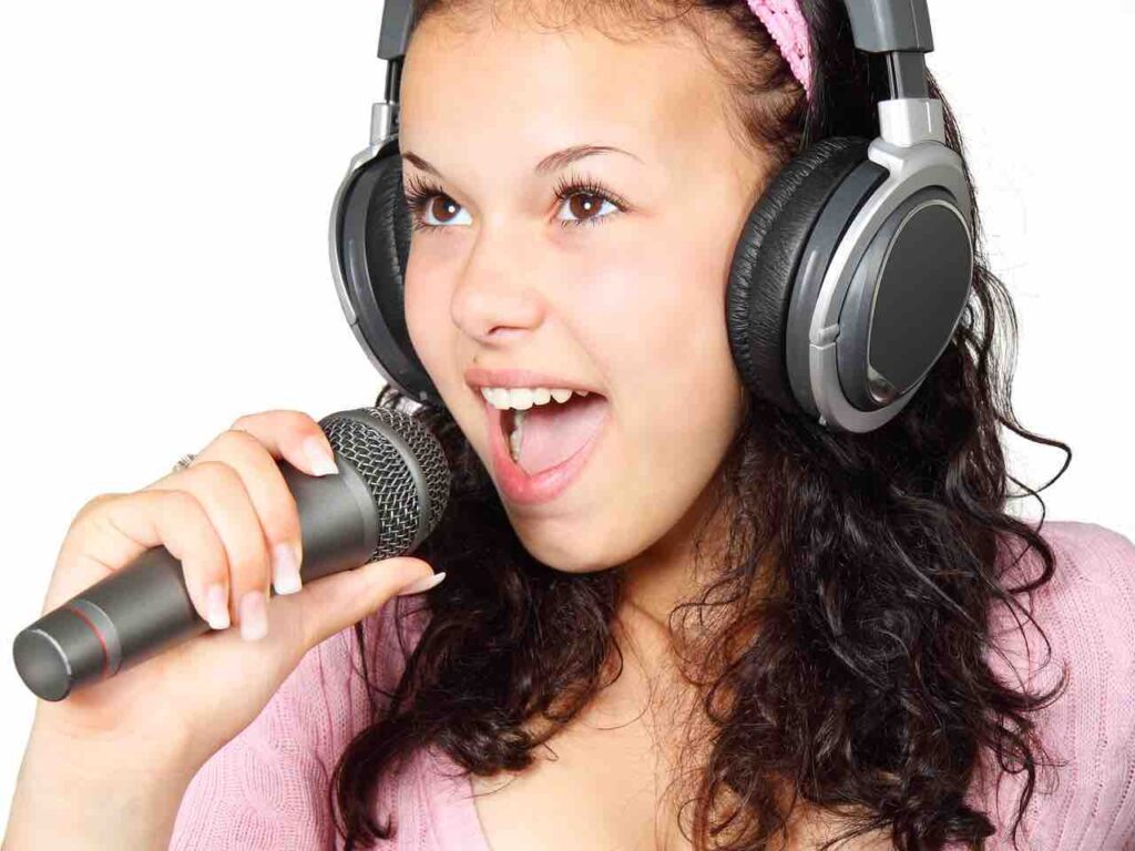 healthy happy woman with headphones singing into microphone